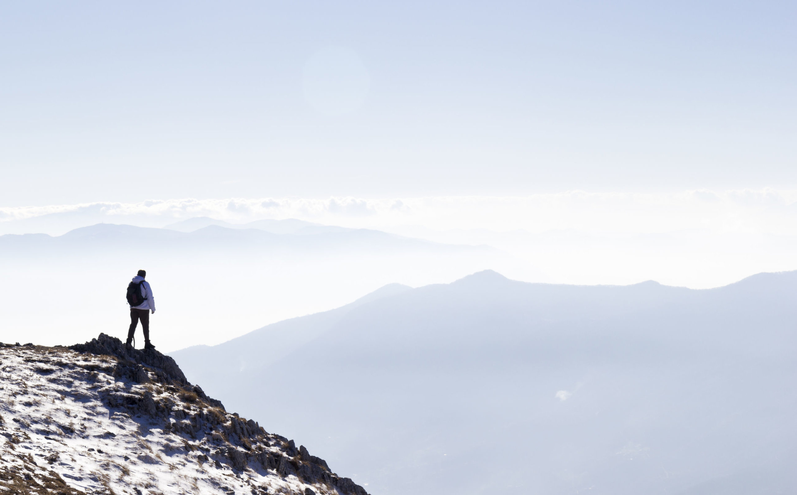 Hiker on the summit of a mountain and snow
